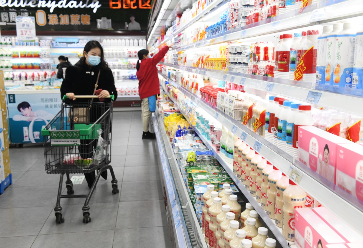Consumers browse dairy products at a supermarket in Shijiazhuang, Hebei province, on Dec 9, 2021.