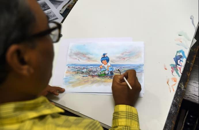 Cartoonist Jayant Rane puts the finishing touches to a sketch of a new Amul advertisement in 2018. (Punit Paranjpe/AFP/Getty Images)